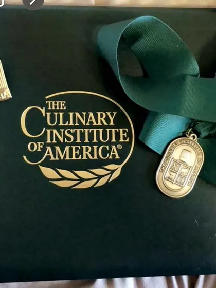 My diploma and medal from the Culinary Institute of America. These are not just objects; they represent a dream I worked hard to achieve and the foundation of my culinary skills.