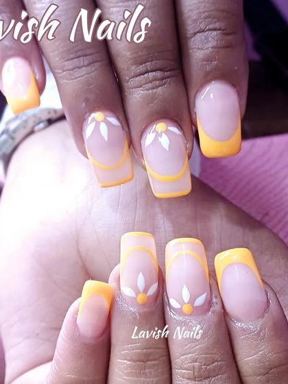 A cheerful yellow French manicure with simple, hand-painted white daisy accents.