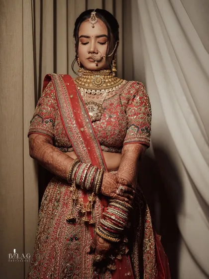 A serene portrait of a Garhwali bride. Her look is traditional and powerful, with a statement gold choker and a large nath, complemented by bold, defined makeup.