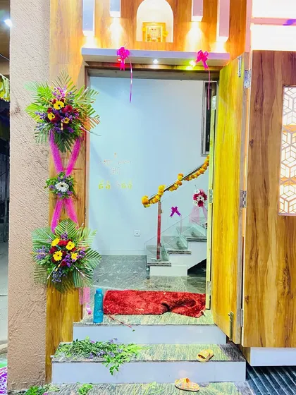 Elegant floral arrangements decorating the entrance of a home for a special occasion.