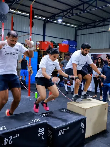 Synchronized box jumps in the heat of competition. This movement requires timing, coordination, and trust between teammates.