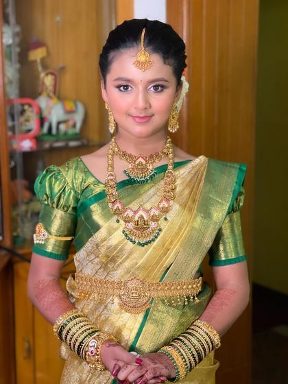 The full look for Mugdha's half-saree ceremony. She looks like a doll in her traditional gold and green outfit.