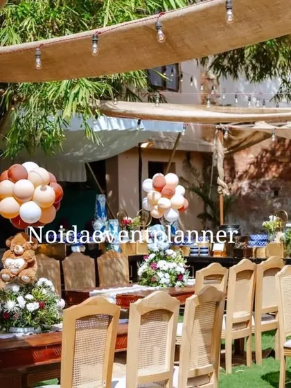 For this boho baby shower, we set up outdoor seating with rustic wooden tables and chairs, decorated with teddy bear balloon centerpieces.
