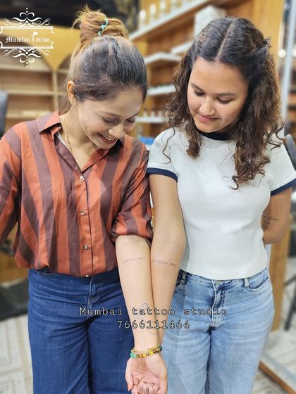 Another pair of friends showing off their matching script tattoos. A shared quote or phrase is a wonderful way to solidify a bond.