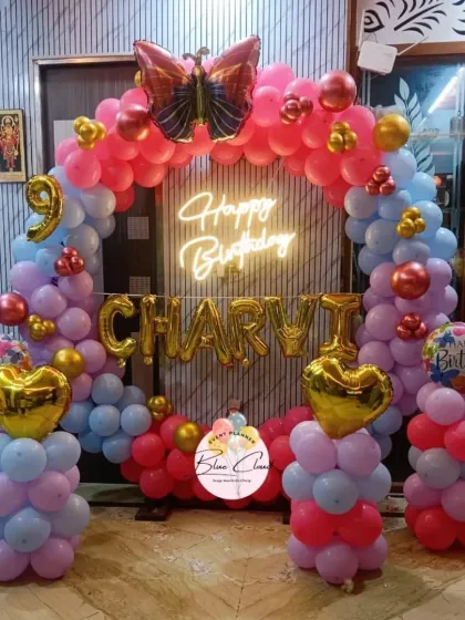 A colorful balloon arch with heart and butterfly foils for a 9th birthday party.