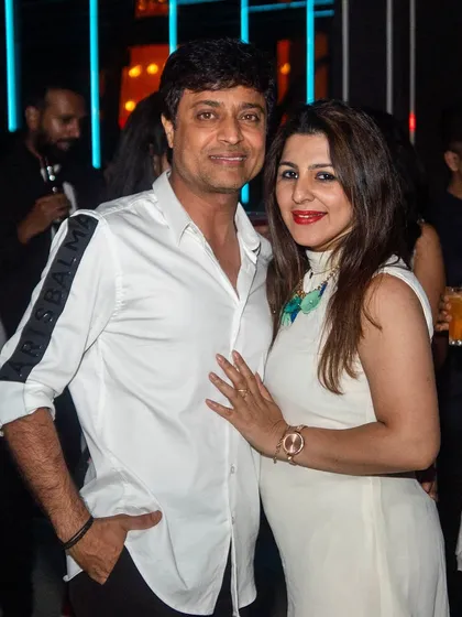 A stylish couple dressed in white for the party.