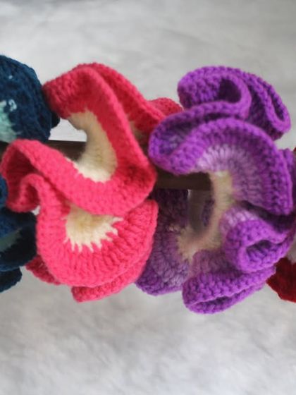 A lineup of my ruffled crochet scrunchies. These are made with two colors to create a fun, frilly effect.