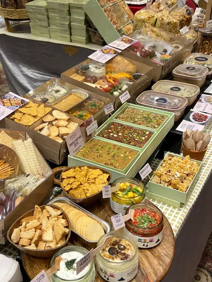 It was a joy to see my signature dips, salads, and desserts completely sell out at the Jalsa Exhibition. This is a snapshot of my stall, bustling with happy customers and showcasing the variety of ready-to-eat items I offer.