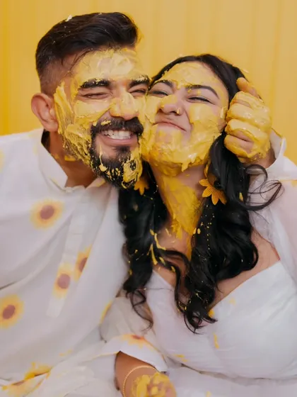 The Haldi ceremony is pure, unscripted fun. I focus on capturing the genuine laughter and playful energy, like this moment where the couple is covered in turmeric paste, completely lost in their joy.