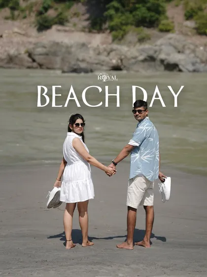 A photo of a couple walking on the beach, shoes in hand, perfectly capturing a relaxed 'Beach Day' vibe.