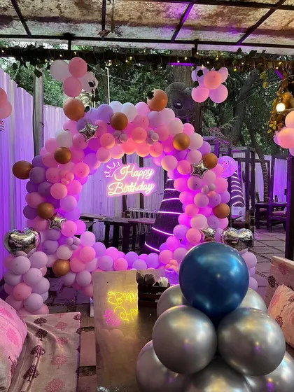 The main birthday backdrop at the outdoor cafe, featuring a balloon ring with star and heart-shaped foil balloons.