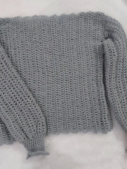 A flat-lay of the Vevitha Sweater, highlighting the delicate mesh pattern and the soft, fuzzy texture of the yarn.