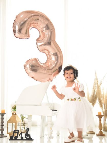 A bright and clean setup for a third birthday. The minimalist boho decor with a pop of rose gold from the balloon creates a modern and stylish look.
