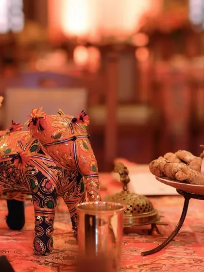 A beautiful detail shot of a decorated elephant figurine, a common symbol of royalty and good fortune in Rajasthani culture, used as a table centerpiece.