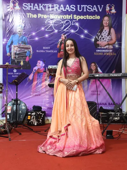 On stage at the Shakti Raas Utsav, an event I organized from the ground up. This photo captures the feeling of a successful show, standing in front of a banner that represents months of planning and passion.