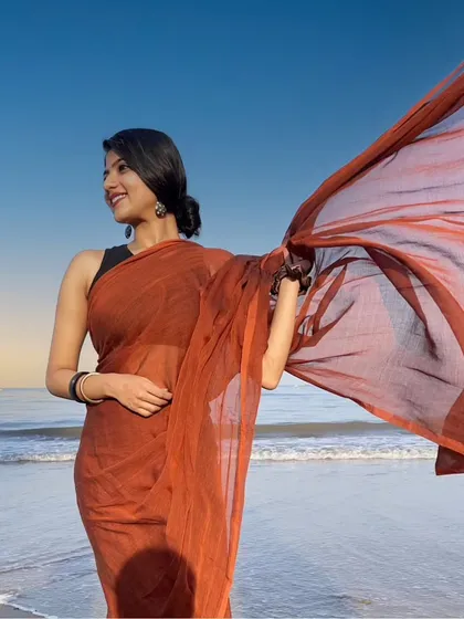 The simplicity of a cotton saree against the vastness of the sea. This shot captures the fabric's beautiful movement in the wind, creating a feeling of freedom and natural elegance.