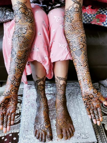 A complete and stunning bridal mehndi look, with intricate patterns covering both hands and feet.