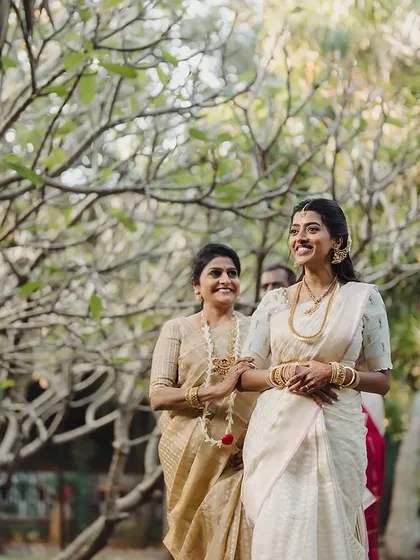 A bride walks through the garden, her path lit by the soft morning sun, creating a serene and beautiful bridal procession moment.