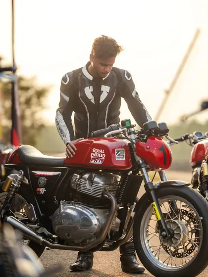 A rider with their Royal Enfield GT 650 at sunset.
