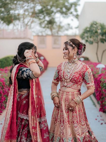 A sweet moment between the bride and her sister. The bride's beautiful updo is visible from the side, showing the intricate details.
