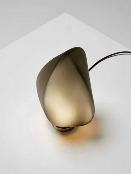 An overhead view of the Solace lamp, showing its unique, transforming shape and the warm pool of light it casts.