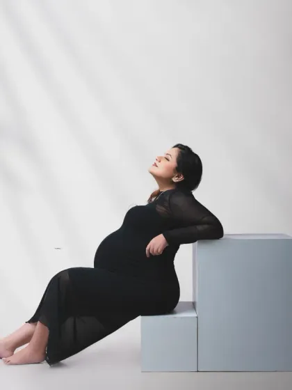 A relaxed and elegant pose. This portrait uses soft, shadowed lighting to create a calm and intimate mood, focusing on the mother's peaceful expression.