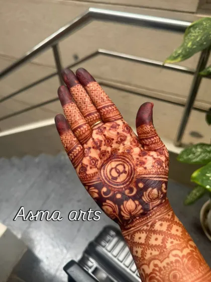 A classic engagement mehendi for the palm, featuring the couple's initials intertwined within a traditional circular pattern, symbolizing their union.