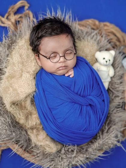 A wise little dreamer. With tiny round glasses and a cozy swaddle, we can create a whimsical, storybook feel for your baby's portraits.