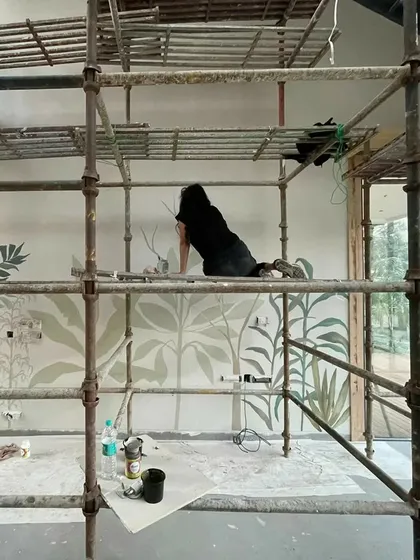My work often takes me to great heights. Here I am on the scaffolding, adding the final details to a 20-foot high tropical mural. Every project is an adventure, and I embrace the physical challenges to bring a vision to life.