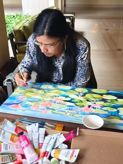 This is me doing what I love most, live painting at the ITC Gardenia hotel. Here, I'm working on a lotus pond scene, surrounded by my acrylics. This experience allows me to connect with people and share my creative process directly.