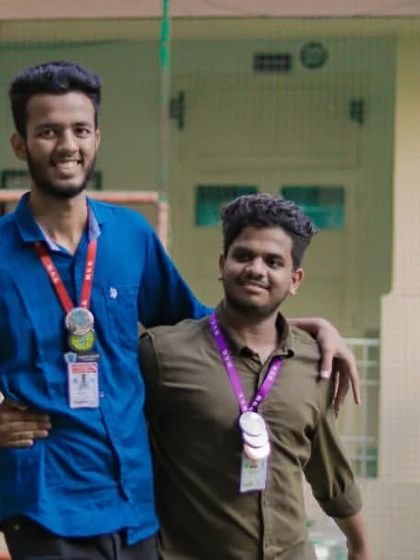Two friends with their medals, a candid moment captured during the daytime events of a college festival.