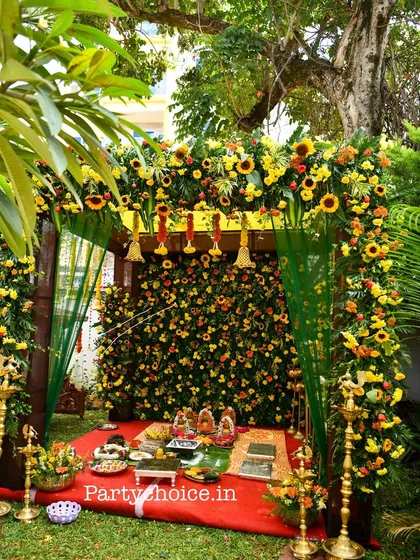 We specialize in creating beautiful outdoor settings for traditional ceremonies. This pooja mandap features a dense wall of sunflowers and marigolds, framed by a lush floral arch, perfect for housewarmings or naming ceremonies.