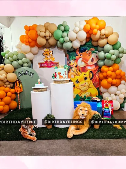 This Lion Guard themed first birthday party features a large backdrop with all the main characters. I used plinths for the cakes and scattered plush animal toys on a green turf floor to make the scene feel interactive and fun.