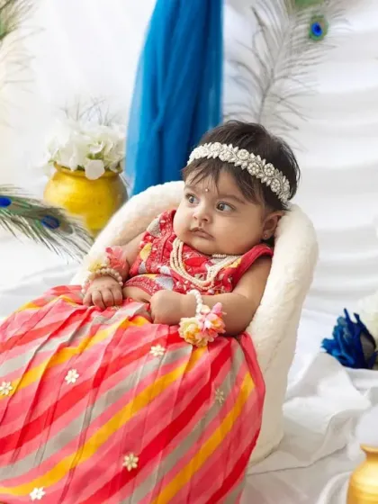 A thoughtful little Radha sitting on her throne. The details, from the pearl headband to the floral bracelets, make this Janmashtami setup so special.