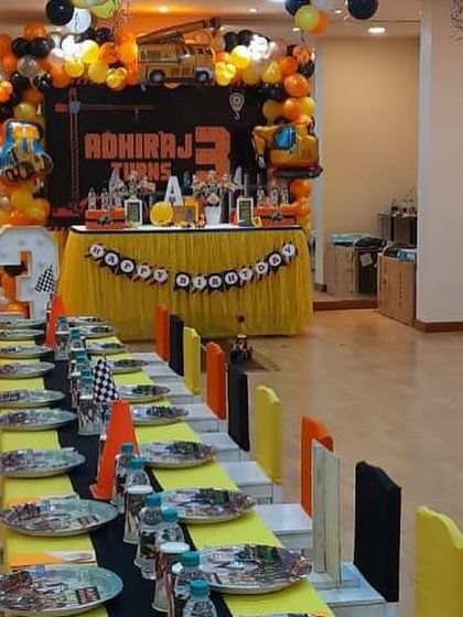 A full venue setup for a construction-themed 3rd birthday, including a large backdrop and themed table settings for all the little guests.