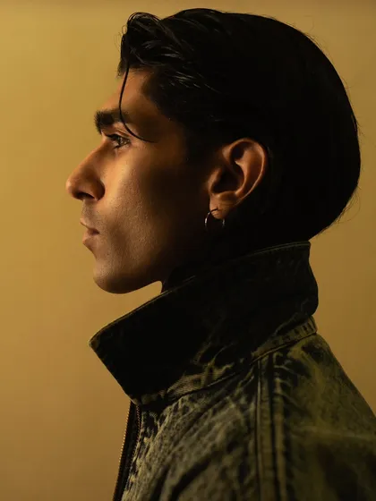 A classic profile portrait with warm, directional lighting. This type of clean, well-lit shot is perfect for a model's portfolio, showcasing his features clearly.
