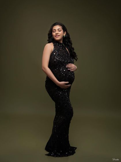 Cradling her bump, this mother-to-be exudes a quiet confidence and joy. The simple pose allows the texture of the gown and her expression to shine.