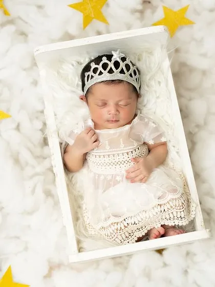 A little princess dreaming among the stars. I use simple props like a tiny crown and a soft, cloud-like bed to create a sweet and elegant fairytale setting.