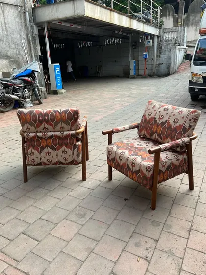 A pair of lounge chairs with a bold, ikat-style patterned fabric.