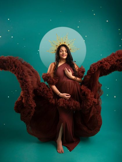 An artistic portrait with flowing fabric that mimics wings. The celestial background and golden halo give this image a divine and otherworldly feel.