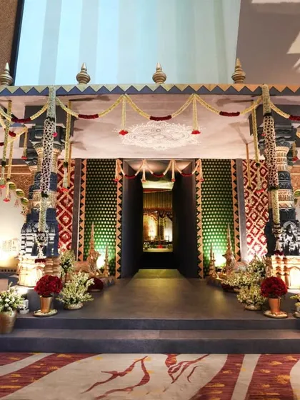 The magnificent double-decker entryway we constructed to lead guests into the temple-themed wedding hall. The structure is adorned with traditional patterns, floral garlands, and pillars that echo the design of the main space.