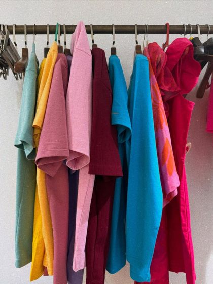 This is a behind the scenes look at my process. A clothing rack filled with colorful options represents the palette from which I create. Each piece is a potential part of a story, waiting to be assembled.