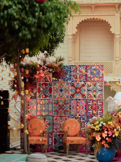 A vibrant and colorful photo booth with a backdrop of traditional tiles. This seating area at a Mehendi in Udaipur was a popular spot for pictures.