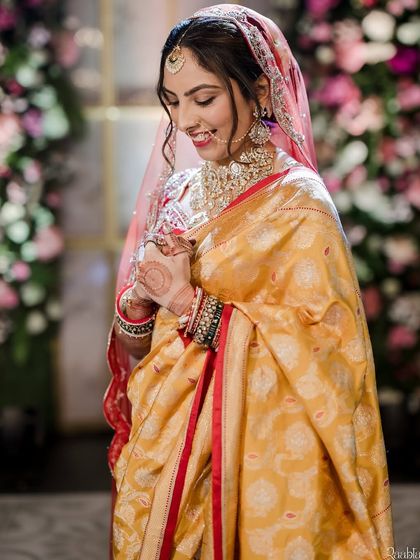 A bride glowing in a traditional yellow saree. The makeup is warm and radiant, with a soft updo that complements the classic elegance of her wedding day attire.