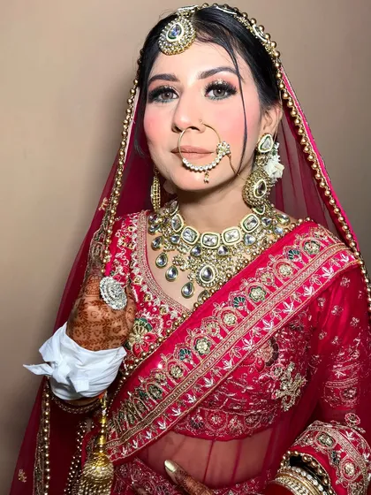 A stunning bride in a magenta lehenga, styled with a heavy polki necklace and a delicate nath.