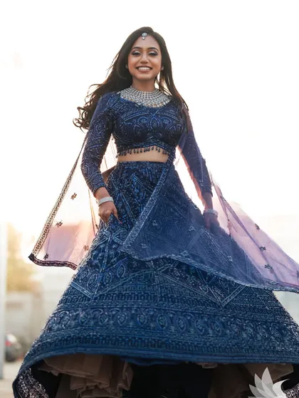 Capturing the pure joy of a reception look. My beautiful bride, Dr. Akshara, is absolutely radiant in this twirling shot, showcasing her sparkling navy blue lehenga. The glam makeup and flowing hair were designed to be perfect for a night of celebration.