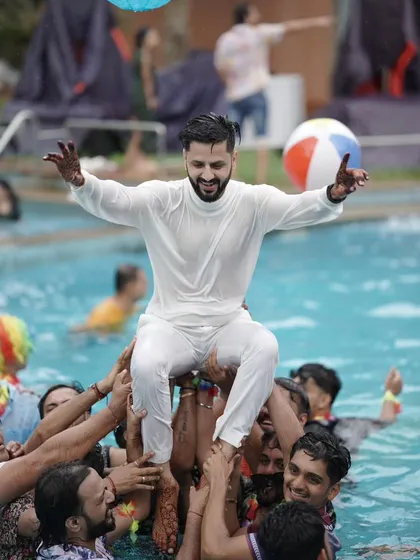 The groom is celebrated by his friends, lifted above the crowd in the swimming pool. These are the fun, candid shots that tell the story of your celebration.