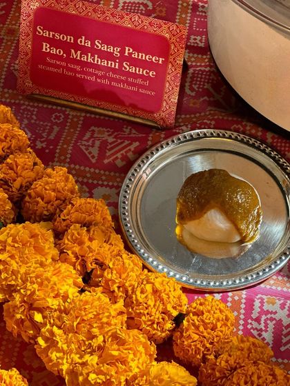 A creative fusion of North Indian and Pan-Asian cuisines: Sarson da Saag Paneer Bao. A soft, steamed bao bun is stuffed with classic mustard greens and cottage cheese, served with a dollop of makhani sauce.