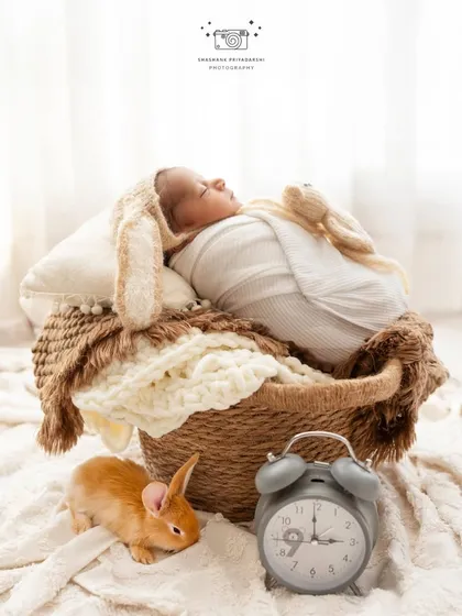 A creative newborn setup featuring a baby with bunny ears, a real bunny, and a clock. We love bringing imaginative ideas to life in our studio.
