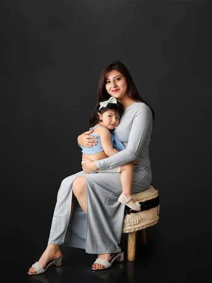 There is nothing more powerful than the bond between a mother and her child. In this classic studio portrait, the simple dark background puts all the focus on their loving embrace, creating a timeless and elegant family photograph.